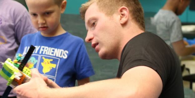 Instructor helping kids with Robotics camp