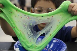 Adding colorful charms and glitter at the premium DIY Slime Bar in Katy and Sugar Land.